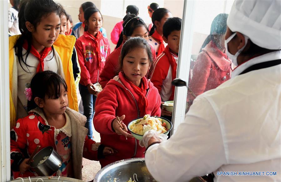 Alumnos de una escuela primaria del poblado Naha del distrito autónomo de la etnia hani de Mojiang de la provincia suroccidental china de Yunnan disfrutan de su almuerzo gratuito. Actualmente, cerca de 27 mil alumnos del distrito comen en escuelas.