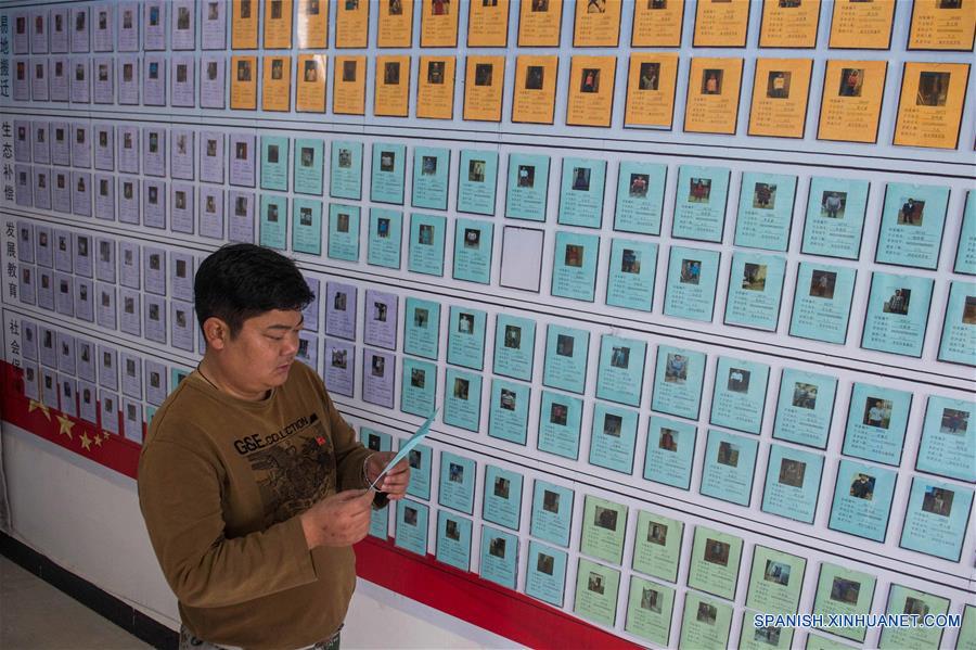Zhou Xiaocong, miembro del grupo de eliminación de pobreza en Mojiang revisa datos de los habitantes de pocos recursos el 16 de enero del año presente.  