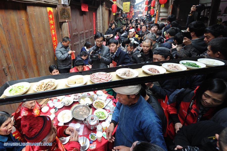 Imagen del 7 de febrero de 2013, de un hombre cargando en la cabeza una bandeja con platos durante un banquete tradicional por el Año Nuevo Lunar chino en el municipio de Zhongshan de la municipalidad de Chongqing, en el suroeste de China. El espíritu más importante del Año Nuevo Lunar chino, o Festival de Primavera, es la reunión familiar. Es también la mejor época para que las personas de todas las edades se reúnan a disfrutar de una deliciosa comida. (Xinhua/Li Jian)