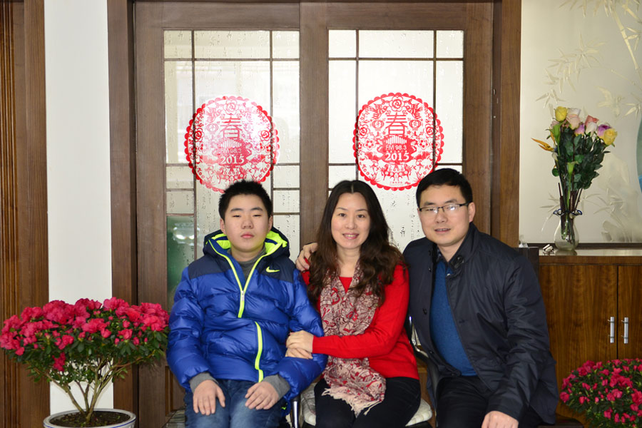 Yu Hui, en el centro, posa con su esposo y su hijo en su casa de la ciudad de Rugao, provincia de Jiangsu, el 19 de febrero de 2015. [Foto / VCG]