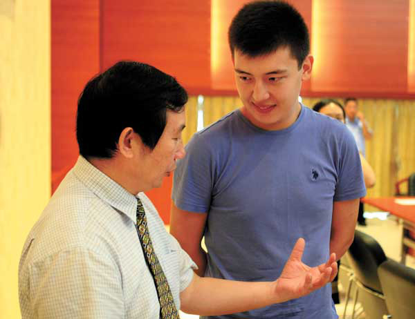Li Jianbao, presidente de la Universidad de Hainan, felicita a Tulenov Ruslan por donar sangre. [Foto: Huang Yiming]