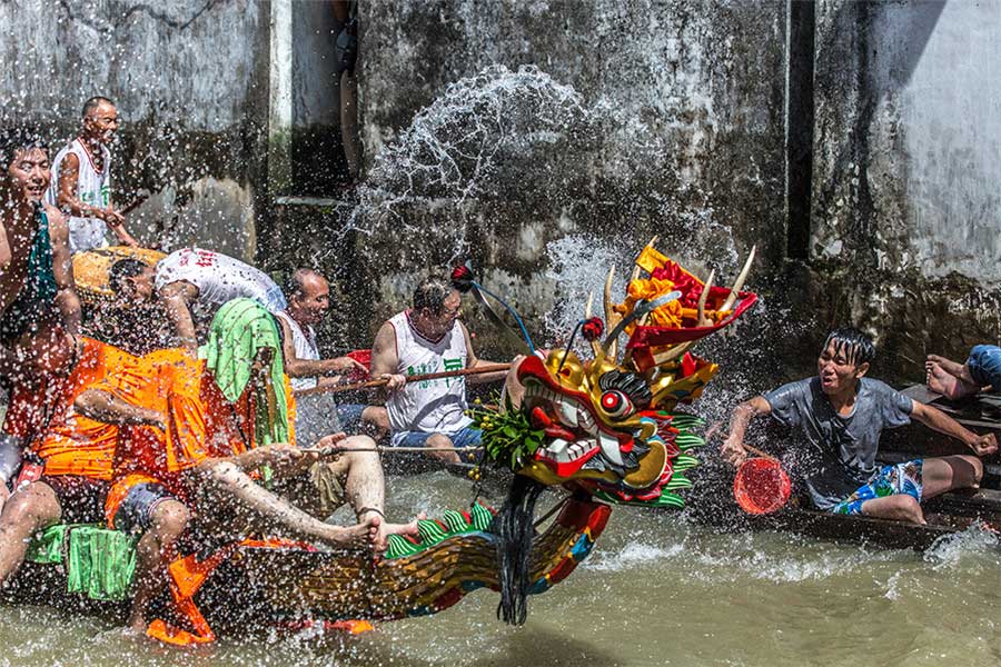 La gente se lanza agua después de una carrera de botes de dragón. Foto de Lu Zhihao. [Foto proporcionada por photoint.net]
