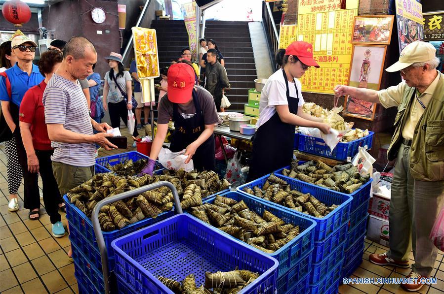 TAIPEI, mayo 29, 2017 (Xinhua) -- Personas compran "zongzi", dumplings con forma de pirámide elaborados con arroz glutinoso, envueltos en hojas de bambú o caña, en un mercado en Taipei, Taiwan, en el sureste de China, el 29 de mayo de 2017. (Xinhua/Liu Junxi)