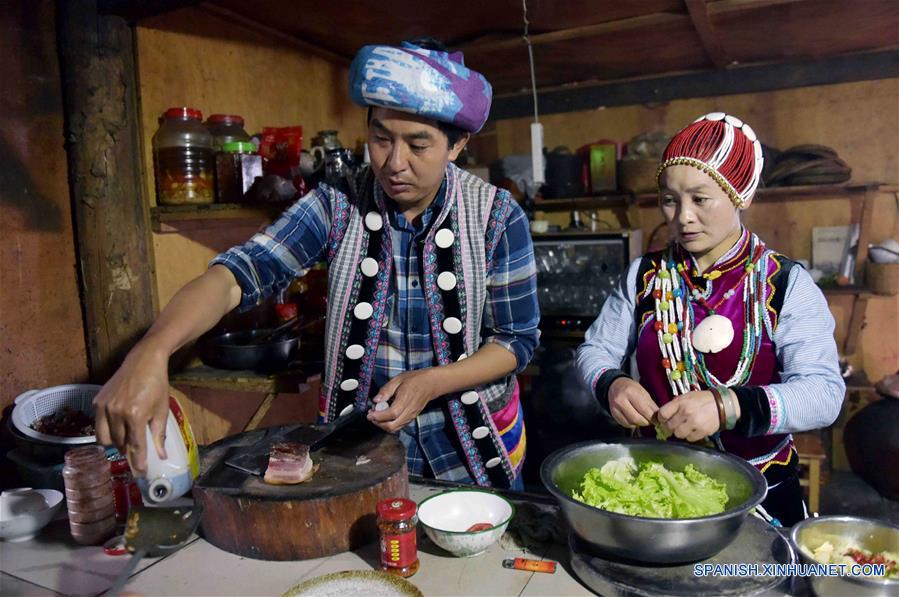  Imagen del 26 de mayo de 2017, de Yu Wulin (i) y su esposa Lu Binghua (d) cocinando para los huéspedes en su estancia familiar en el poblado de Laomudeng en el municipio étnico de Pihe Nu, en la provincia de Yunnan, en el suroeste de China. En 1996, Yu Wulin fue elegido para promover la cultura del grupo étnico Nu en Shanghai y se enamoró de la bailarina Lu Binghua. Después de regresar a su ciudad natal, se casaron y abrieron una estancia familiar para turistas. Crearon una marca de té y vendieron sus productos locales de té a mercados extranjeros. Gracias a la inspiración de la pareja, muchos residentes locales abrieron estancias familiares, y la vida ha cambiado en el poblado remoto. (Xinhua/Yang Zongyou)