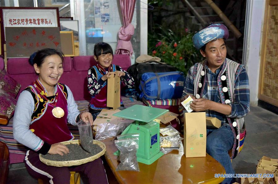 Imagen del 26 de mayo de 2017, de Yu Wulin (d), su esposa Lu Binghua (i) y su hija empacando té en su casa en Laomudeng en el municipio étnico de Pihe Nu, en la provincia de Yunnan, en el suroeste de China. En 1996, Yu Wulin fue elegido para promover la cultura del grupo étnico Nu en Shanghai y se enamoró de la bailarina Lu Binghua. Después de regresar a su ciudad natal, se casaron y abrieron una estancia familiar para turistas. Crearon una marca de té y vendieron sus productos locales de té a mercados extranjeros. Gracias a la inspiración de la pareja, muchos residentes locales abrieron estancias familiares, y la vida ha cambiado en el poblado remoto. (Xinhua/Yang Zongyou)