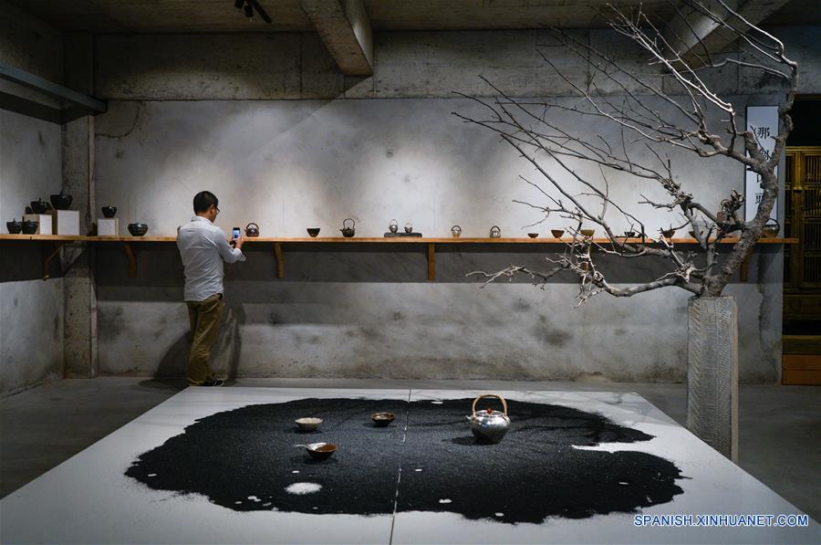 Un hombre toma fotografías durante una exhibición de porcelana de Cao Qingli, un artesano de la ciudad de Liuzhou, en el Museo True Color en Suzhou, en la provincia de Jiangsu, en el este de China, el 29 de mayo de 2017. La exhibición muestra más de 90 obras de "juci", una técnica tradicional de arreglar porcelana con grapas. Estará abierta hasta el 31 de diciembre. (Xinhua/Li Xiang)
