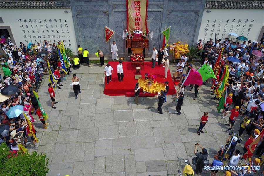Personas observan una danza del dragón durante una ceremoni del Festival Duanwu, en el Parque del Humedal Nacional Xixi, en Hangzhou, capital de la provincia de Zhejiang, en el este de China, el 30 de mayo de 2017. La ceremonia consite en diversas actividades relacionados en el Festival Duanwu o Festival del Bote del Dragón mientras se lleva a cabo la danza del dragón y competencias de bote de dragón. (Xinhua/Zhang Cheng)
