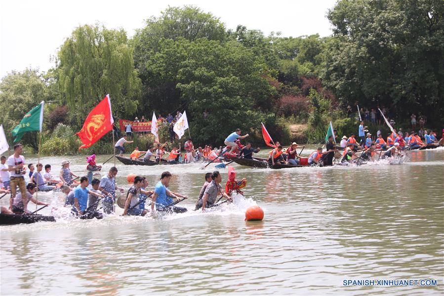 Personas participan en una carrera de bote de dragón durante una ceremoni del Festival Duanwu, en el Parque del Humedal Nacional Xixi, en Hangzhou, capital de la provincia de Zhejiang, en el este de China, el 30 de mayo de 2017. La ceremonia consite en diversas actividades relacionados en el Festival Duanwu o Festival del Bote del Dragón mientras se lleva a cabo la danza del dragón y competencias de bote de dragón. (Xinhua/Zhang Cheng)