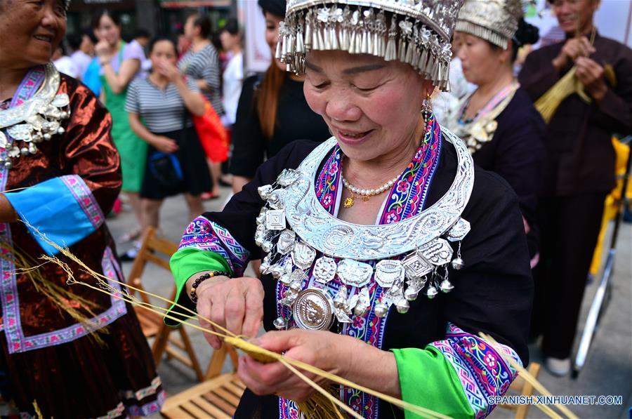 Una mujer Dong muestra cómo elaborar Caolong, dragón hecho con paja de arroz pegajosa para ser tejida en los festivales, durante una exhibición de patrimonio cultural en Longsheng, en la Región Autónoma Zhuang de Guangxi, en el sur de China, el 9 de junio de 2017. (Xinhua/Li Xuanli)  
