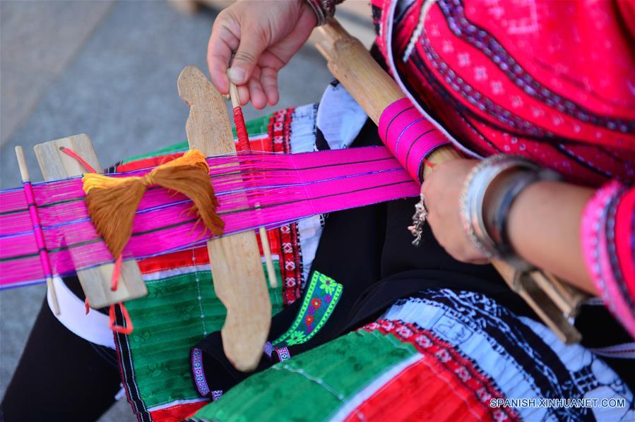  Una mujer del grupo étnico Yao muestra cómo elaborar prendas tradicionales de su etnia, durante una exhibición de patrimonio cultural en Longsheng, en la Región Autónoma Zhuang de Guangxi, en el sur de China, el 9 de junio de 2017. (Xinhua/Li Xuanli)