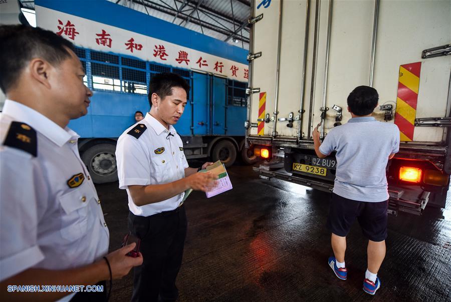 GUANGDONG, junio 18, 2017 (Xinhua) -- Imagen del 16 de junio de 2017, de empleados de inspección y cuarentena revisando la factura de las mercancías en el centro de comercio de vegetales de Runfeng en Dongguan, en la provincia de Guangdong, en el sur de China. Según las estadísticas de las autoridades locales, más del 85 por ciento de los vegetales, frutas y aves de corral vivas que llegaron desde la parte continental de China a los mercados de Hong Kong, fueron transportados a través del puerto Wenjindu de Shenzhen. (Xinhua/Mao Siqian)
