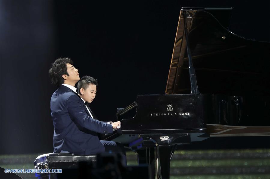 El pianista Lang Lang, interpreta una melodía junto a un niño durante una gala de noche llevada a cabo en celebración del 20 aniversario del retorno de Hong Kong a la patria, en Hong Kong, en el sur de China, el 30 de junio de 2017. (Xinhua/Ding Lin)