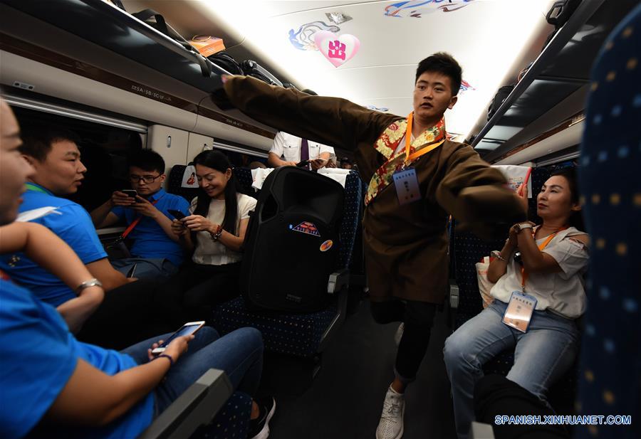 SHAANXI, julio 9, 2017 (Xinhua) -- Un empleado realiza una danza tibetana sobre el tren bala D2685 que parte desde Xi'an, en la provincia de Shaanxi, en el noroeste de China, el 9 de julio de 2017. Una nueva línea ferroviaria de alta velocidad que enlaza la ciudad de Baoji, en la provincia noroccidental china de Shaanxi, con Lanzhou, capital de la provincia vecina de Gansu, entró en operación el domingo. Gracias a esta nueva línea, las provincias de Gansu y Qinghai, así como la región autónoma uygur de Xinjiang, todas ubicadas en el noroeste de China, se han unido a la red nacional de ferrocarriles de alta velocidad. (Xinhua/Liu Xiao)
