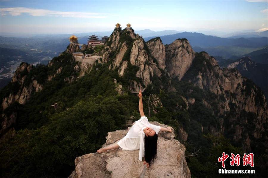 Maestra de yoga posa sobre los impresionantes acantilados de Henan 2