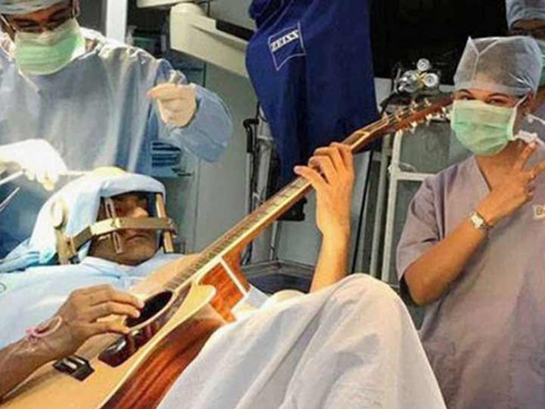 Joven indio toca la guitarra mientras le operan el cerebro