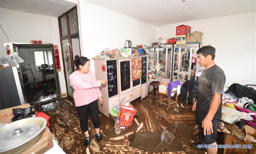 Residentes limpian su vivienda en la aldea Daheyan, en el condado de Xiuyan de Anshan, en la provincia de Liaoning, en el noreste de China, el 4 de agosto de 2017. Una lluvia torrencial afectó al condado el jueves y viernes, dañando caminos, instalaciones de electricidad y cultivos en algunos municipios. Un total de 18,900 personas han sido trasladadas a lugares seguros, y la ciudad ha iniciado el nivel 1 de respuesta de emergencias para enfrentar las posibles inundaciones. (Xinhua/Yang Qing)
