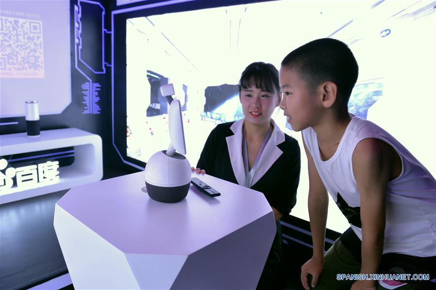 Niños juegan con un robot en el autobús de experimentación de Inteligencia Artificial (AI, por sus siglas en inglés), en el Museo de Ciencia y Tecnología de China, en Beijing, capital de China, el 4 de agosto de 2017. Baidu y el Museo de Ciencia y Tecnología de China co-organizaron la ceremonia de lanzamiento del autobús de popularización de la ciencia AI el viernes. Comenzando desde Beijing, el autobús llevará el conocimiento de la AI a cuatro ciudades más en China. (Xinhua/Wang Huajuan)