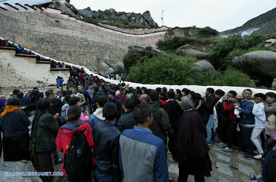 LHASA, agosto 21, 2017 (Xinhua) -- Budistas y creyentes cargan na gran pintura "thangka" de Buda para ser exhibida en el Monasterio Drepung en Lhasa, capital de la región autónoma del Tibet, en el suroeste de China, el 21 de agosto de 2017. Budistas y creyentes llegaron a Lhasa para el inicio del tradicional Festival Shoton. El Festival Shoton, también conocido como el Festival del Banquete de Yogurt, es una gala de una semana llevada a cabo desde el siglo XI. (Xinhua/Liu Dongjun)