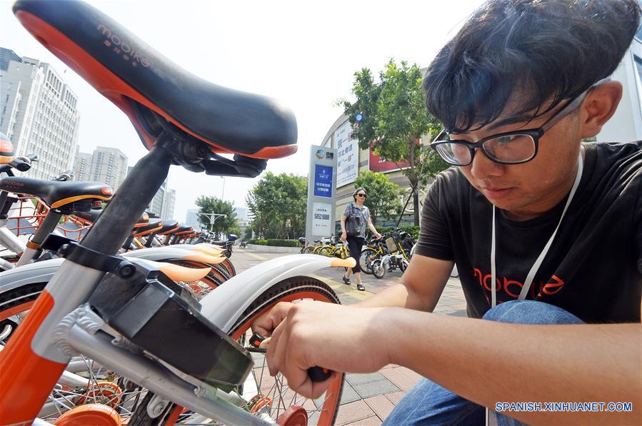 TIANJIN, agosto 21, 2017 (Xinhua) -- Un despachador de bicicletas compartidas repara una bicicleta dañada en Tianjin, en el norte de China, el 21 de agosto de 2017. A pesar del clima sofocante en Tianjin, los despachadores, que también son trabajadores de mantenimiento, viajan por la ciudad para asegurar que las biciclets estén en orden y funcionen bien. (Xinhua/Shi Songyu) 