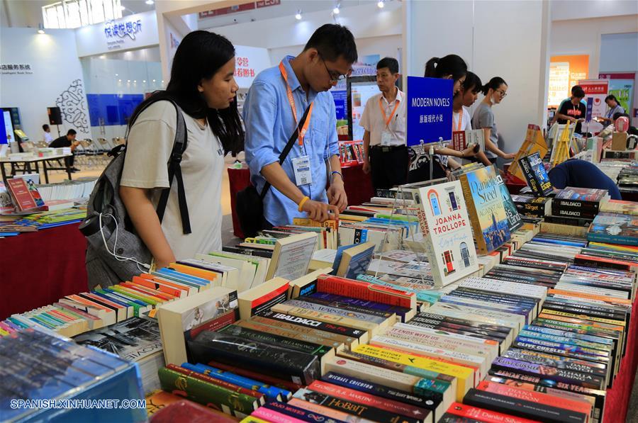 Personas leen libros durante la 24 Feria Internacional del Libro de Beijing llevada a cabo en la Nueva Sede del Centro Internacional de Exposiciones de China, en Beijing, capital de China, el 23 de agosto de 2017.(Xinhua/Liu Xianguo)