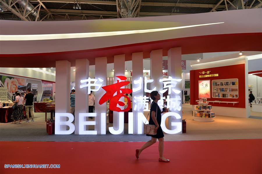 Una mujer camina en la sede de la 24 Feria Internacional del Libro de Beijing llevada a cabo en la Nueva Sede del Centro Internacional de Exposiciones de China, en Beijing, capital de China, el 23 de agosto de 2017. (Xinhua/Wang Huajuan)
