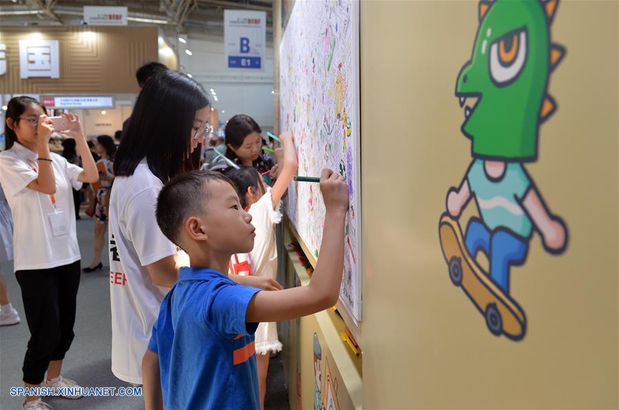 Un niño colorea sobre un tablero en la 24 Feria Internacional del Libro de Beijing llevada a cabo en la Nueva Sede del Centro Internacional de Exposiciones de China, en Beijing, capital de China, el 23 de agosto de 2017.  (Xinhua/Wang Huajuan) 