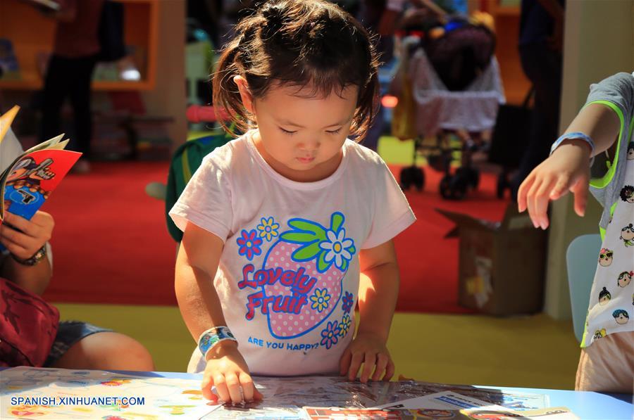 Una niña lee un libro durante la 24 Feria Internacional del Libro de Beijing llevada a cabo en la Nueva Sede del Centro Internacional de Exposiciones de China, en Beijing, capital de China, el 23 de agosto de 2017. (Xinhua/Liu Xianguo)
