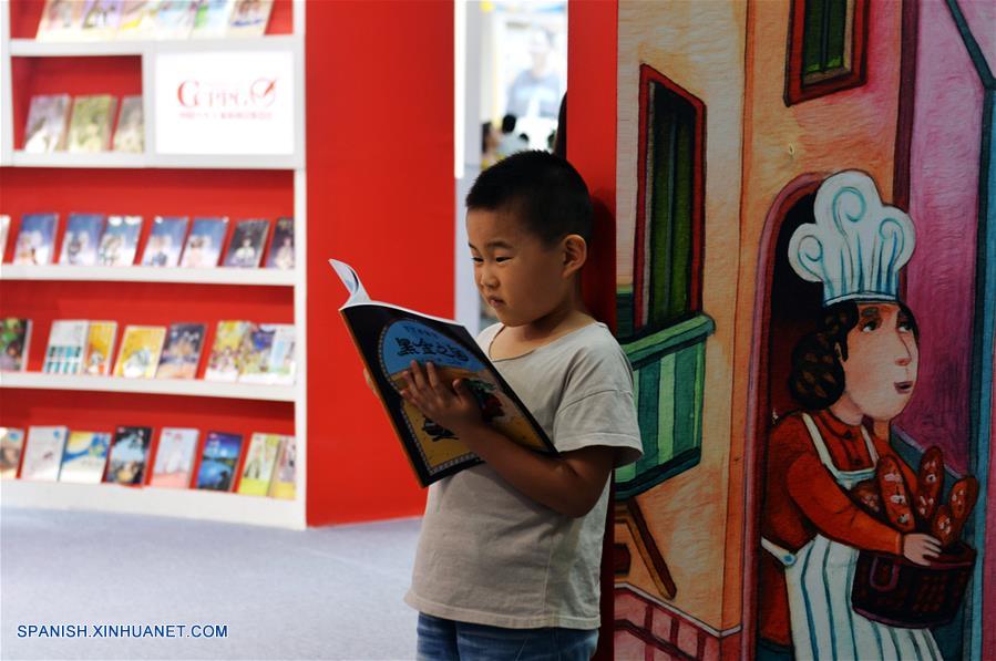 Un niño lee un libro durante la 24 Feria Internacional del Libro de Beijing llevada a cabo en la Nueva Sede del Centro Internacional de Exposiciones de China, en Beijing, capital de China, el 23 de agosto de 2017. (Xinhua/Wang Huajuan)