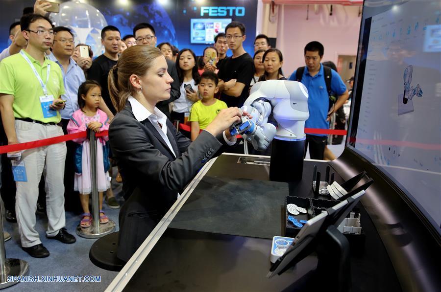 BEIJING, agosto 22, 2017 (Xinhua) -- Una empleada muestra un robot durante la vista previa para los medios de comunicación de la Conferencia Mundial de Robots 2017 llevada a cabo en el Centro Internacional de Conferencias y Exposiciones Yichuang de Beijing, en Beijing, capital de China, el 22 de agosto de 2017. La conferencia se llevará a cabo del 23 al 27 de agosto, con un foro, exposición y concurso de robots. (Xinhua/Jin Liwang)