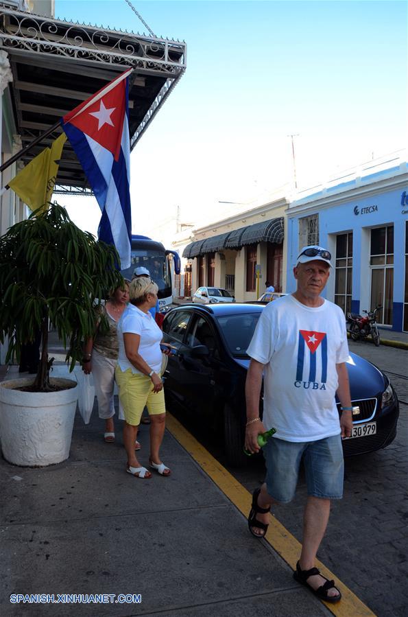 CIENFUEGOS, octubre 20, 2017 (Xinhua) -- Imagen del 13 de octubre de 2017 de turistas extranjeros caminando en una calle en la ciudad de Cienfuegos, Cuba. Ubicada a unos 250 kilómetros al sureste de La Habana, la ciudad de Cienfuegos se ha convertido en la nueva perla del turismo en Cuba con un creciente arribo de vacacionistas. La urbe, unas de las pocas de América fundada por franceses, se alza al borde de una amplia bahía que permite la llegada de cruceros y yates cargados de turistas, procedentes principalmente de Canadá, Alemania y Francia, los principales mercados de la isla, en ese orden. En esa localidad, de calles rectilíneas y arquitectura neoclásica, hay más de 700 casas particulares que rentan arriba de 1,400 habitaciones, las que se suman a las 861 disponibles que tienen las instalaciones hoteleras estatales. La singular arquitectura de la ciudad, diferente al resto de la isla, constituye un atractivo particular para los vacacionistas extranjeros, en especial para los canadienses, que por lo regular están un par de semanas en ese lugar, aunque algunos se quedan dos o tres meses. (Xinhua/Joaquín Hernández)