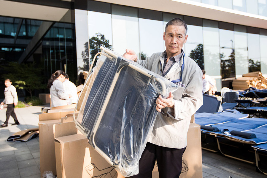 Un miembro del personal de apoyo desempaqueta una cama para el descanso de los empleados del campamento laboral del Festival de Compras 11-11 o Día del Soltero en la sede de Alibaba en Hangzhou, provincia de Zhejiang.31 de octubre del 2017. [Foto: VCG]