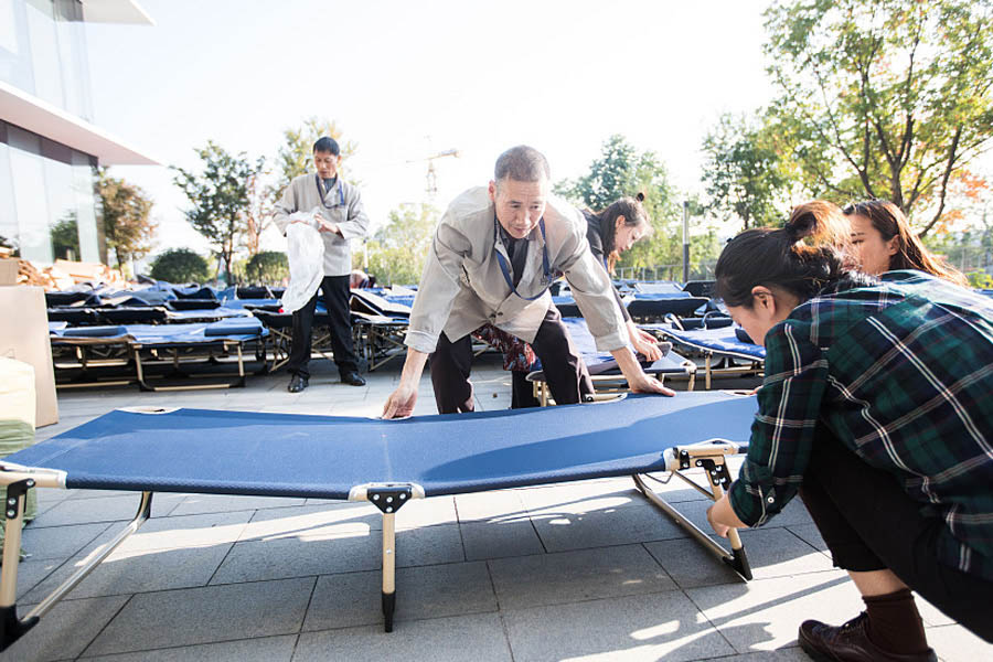 Los miembros del personal de apoyo montan una cama en el campamento laboral del Festival de Compras 11-11 o Día del Soltero en la sede de Alibaba en Hangzhou, provincia de Zhejiang.31 de octubre del 2017. [Foto: VCG]