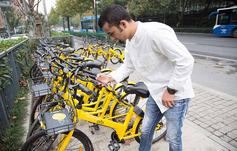 Nayeem Hafeez escanea un código QR para desbloquear una bicicleta compartidaOfo en Hangzhou, provincia de Zhejiang, el 12 de noviembre de 2017. [Foto / VCG]