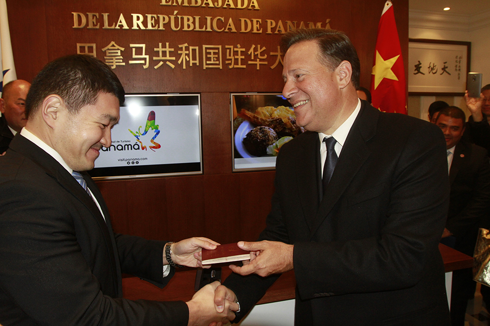 Juan Carlos Varela, presidente de Panamá, entrega a un trabajador de la empresa Huawei su pasaporte chino con la primera visa estampada, emitida por la recién inaugurada Embajada de Panamá en China. (Foto: YAC)