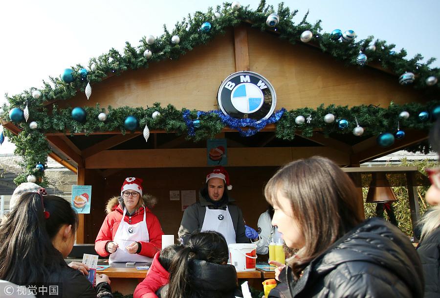 La ya tradicional Feria de Navidad en la Embajada de Alemania en Beijing atrajo a más de 6.000 visitantes, incluidas estas personas en el stand de BMW, el 2 de diciembre de 2017. [Foto / VCG]