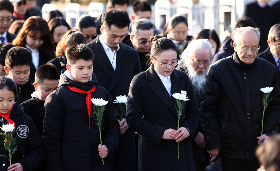La gente reza por las víctimas durante una ceremonia en el Museo de la Guerra de Resistencia China contra la Agresión Japonesa en Beijing, el 13 de diciembre de 2017. [Foto por Zou Hong / China Daily]