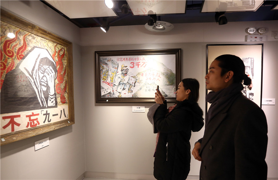 Los visitantesobservan las fotos en una exposición sobre la Masacre de Nanjing en el Museo de la Guerra de Resistencia China contra la Agresión Japonesa en Beijing, el 13 de diciembre de 2017. [Foto por Zou Hong / China Daily]