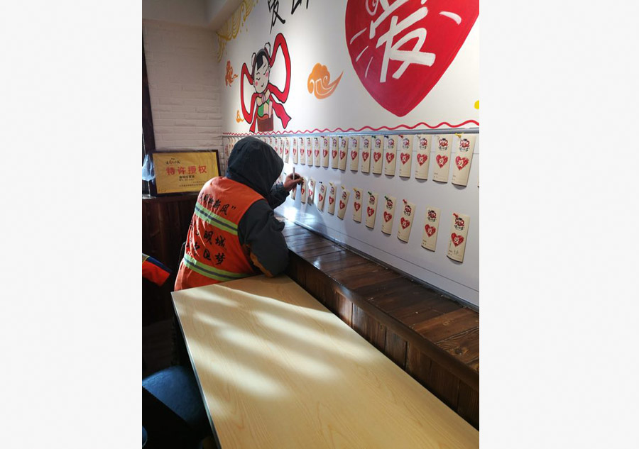 Cada trabajador de saneamiento debe escribir su nombre antes de recibir la comida gratis. [Foto proporcionada a chinadaily.com.cn]