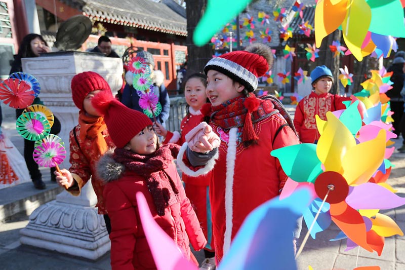Los niños rodeados de molinetes de colores en el Observatorio Antiguo en Beijing para celebrar el periodo del calendario lunar Comienzo de la Primavera, que comenzó el domingo. [Foto de Wang Zhuangfei / chinadaily.com.cn]