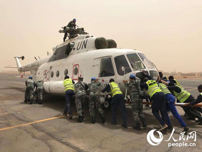 La División de Helicópteros de la Fuerza China para el Mantenimiento de la Paz acomoda los helicópteros que arriban a Jartum, capital de Sudán. (Foto: Diario del Pueblo/Li Yida)