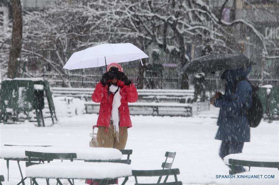 Una mujer toma fotografías bajo la nevada en Madison Square Park en Nueva York, Estados Unidos, el 21 de marzo de 2018. Miles de vuelos fueron cancelados y escuelas públicas cerradas mientras la cuarta tormenta de nieve en tres semanas comenzó a golpear el miércoles la ciudad de Nueva York y sus áreas vecinas, de acuerdo con información de la prensa local. (Xinhua/Wang Ying)