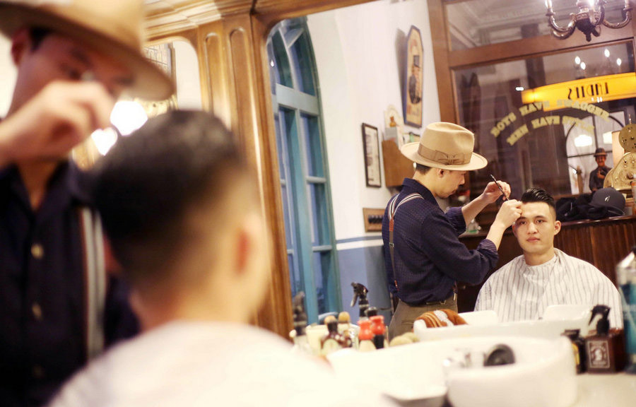 En “La barbería”, Henry realiza un peinado de antaño, Shanghai, 5 de abril del 2018. (Foto: IC)
