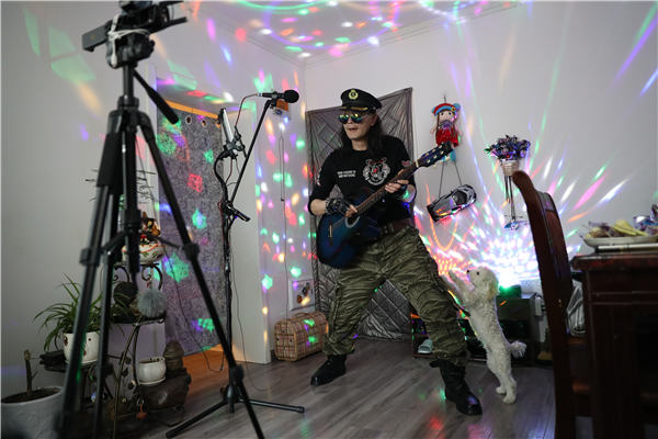 Li Guangfu, de 50 años, transmite en vivo tocando la guitarra para compartir la alegría de su amor de por vida. Ha gastado decenas de miles de yuanes en equipos para mejorar sus actuaciones. [Foto de Zou Hong / China Daily]