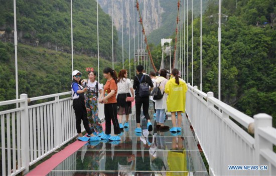 La gente camina en el puente con fondo de vidrio