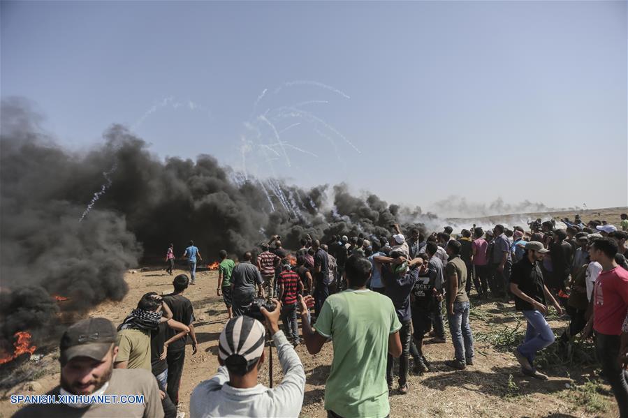 GAZA, junio 8, 2018 (Xinhua) -- Manifestantes palestinos corren para cubrirse del gas lacrimógeno lanzado por soldados israelíes durante enfrentamientos en la frontera entre Gaza e Israel, en el este de la Ciudad de Gaza, el 8 de junio de 2018. Al menos cuatro manifestantes palestinos murieron y 618 resultaron heridos por soldados israelíes durante los enfrentamientos ocurridos el viernes cerca de la frontera Israel-Gaza, dijeron fuentes palestinas. (Xinhua/Wissam Nassar)