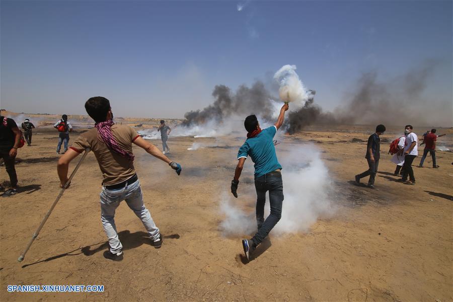 GAZA, junio 8, 2018 (Xinhua) -- Un manifestante palestino devuelve una lata de gas lacrimógeno a los soldados israelíes durante los enfrentamientos con soldados israelíes, en la frontera de Gaza e Israel, en el este de la ciudad de Khan Younis del sur de la Franja de Gaza, el 8 de junio de 2018. (Xinhua/Khaled Omar)