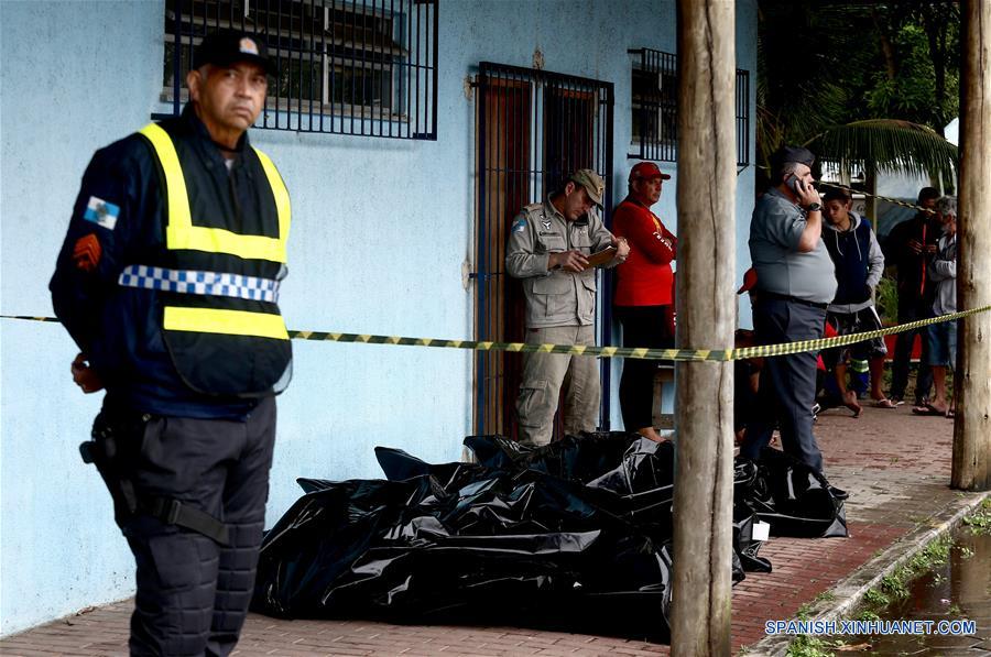 Un policía monta guardia junto a los cuerpos de cuatro víctimas del naufragio que permanecen en la sede de la Secretaría Municipal de Pesca, en Río de Janeiro, Brasil, el 8 de junio de 2018. (Xinhua/Fábio Motta/AGENCIA ESTADO)