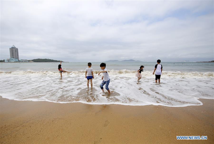 La gente juega en el balneario de Qingdao, E Shandong de China