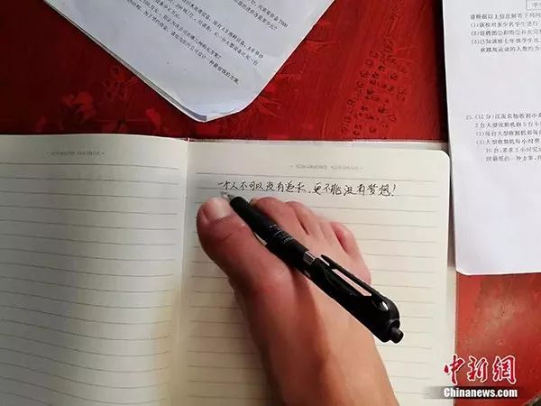 El anciano Wu escribe notas con los dedos de los pies. [Foto/Chinanews. com]