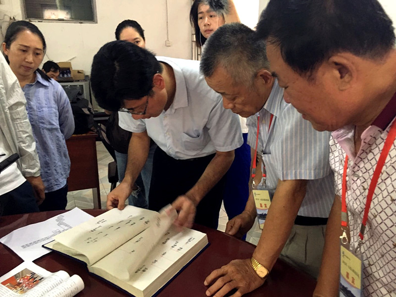 Huang Ching-Hsiung (segundo a la derecha) examina expedientes genealógicos relacionados con su familia en Pujin.